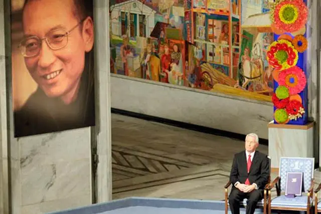 Nobel Commitee chairman Thorbjorn Jagland sits next to an empty chair with the Nobel Peace Prize medal and diploma  during a ceremony honoring Nobel Peace Prize laureate Liu Xiaobo.